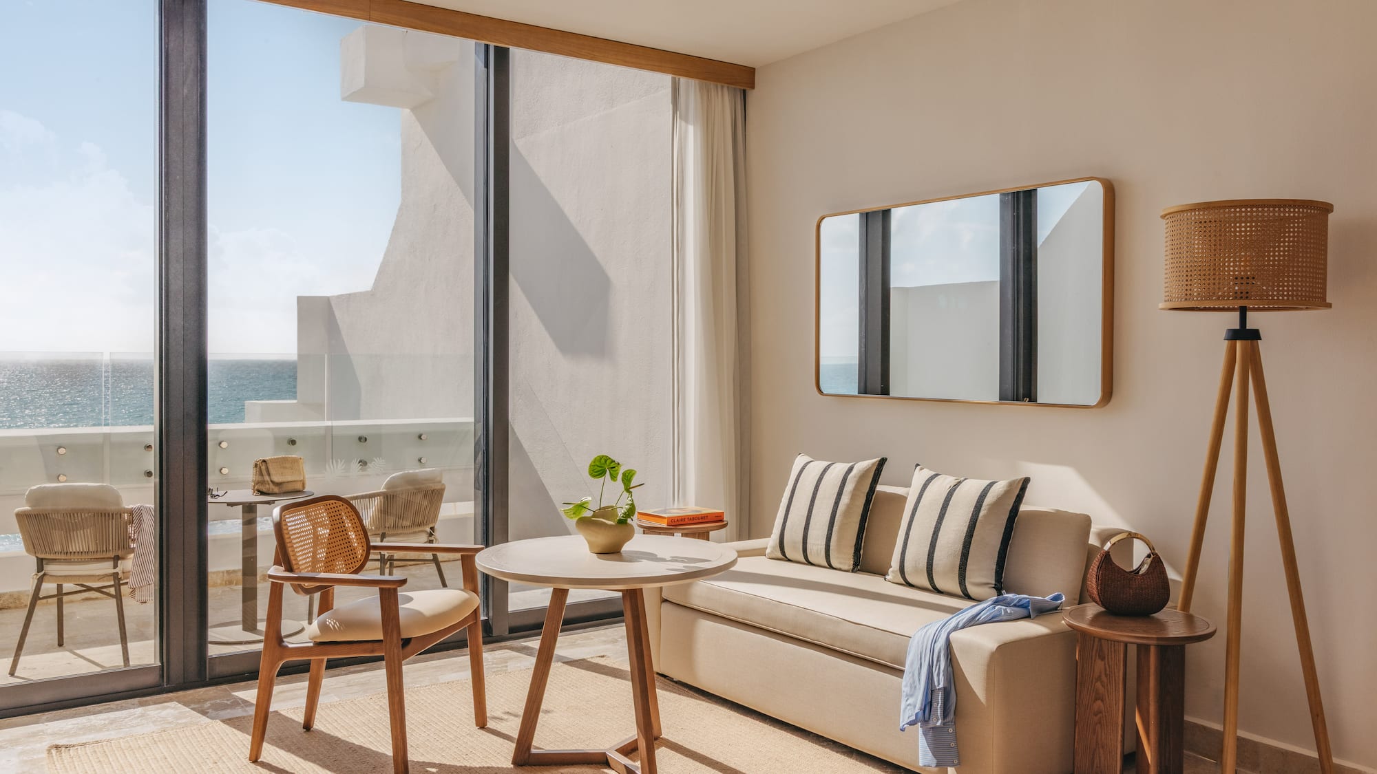 Modern oceanfront hotel room with balcony, sofa, coffee table, and sea view.