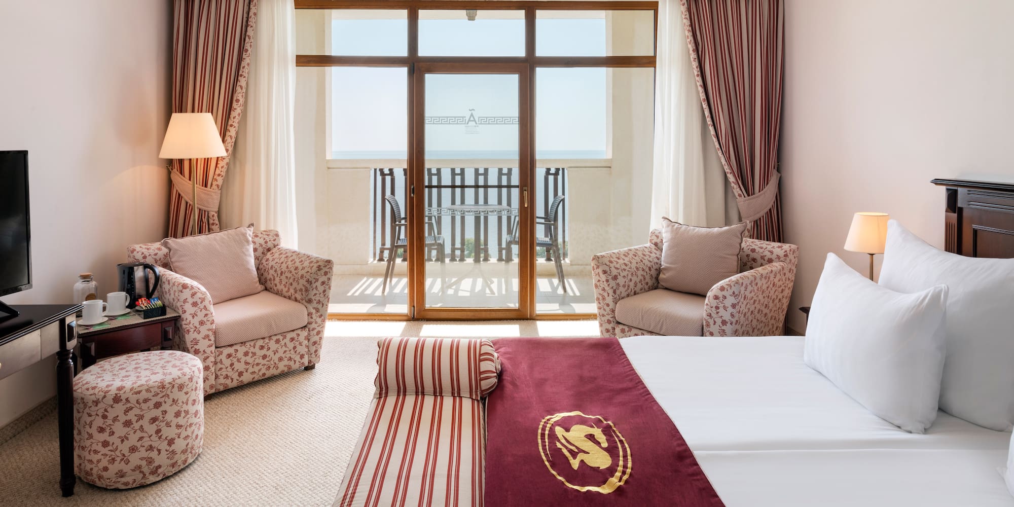 a room with a bed and chairs