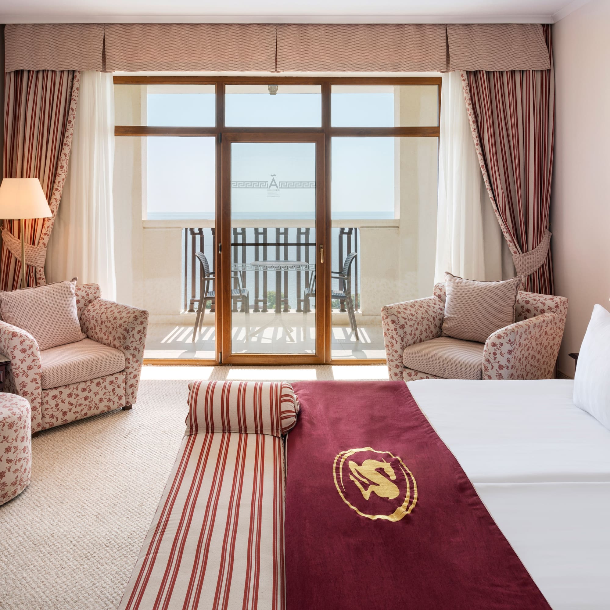 a room with a bed and chairs