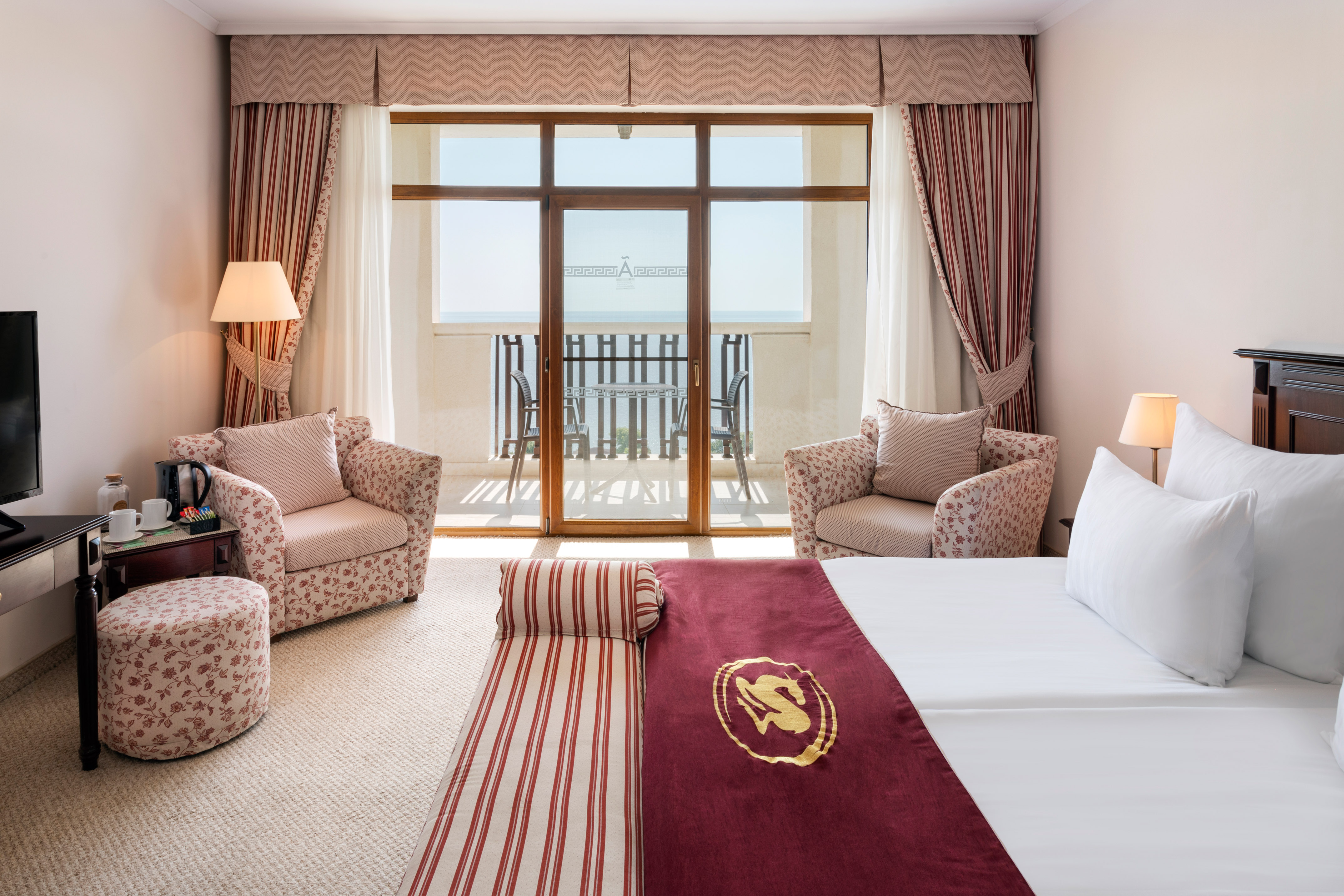 a room with a bed and chairs