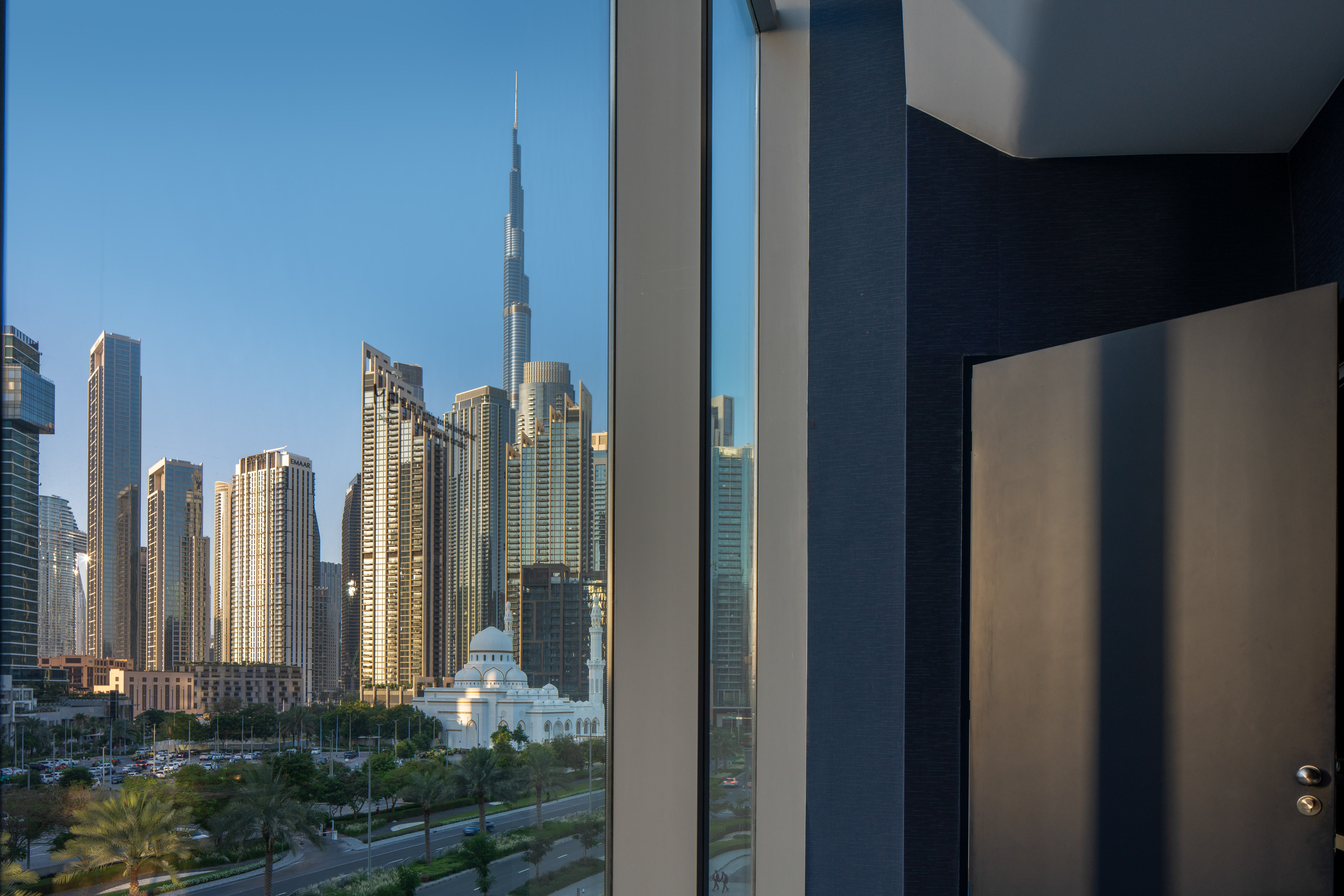 Dubai cityscape view with Burj Khalifa, skyscrapers, and white mosque.