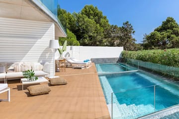 a swimming pool and a deck with a glass fence