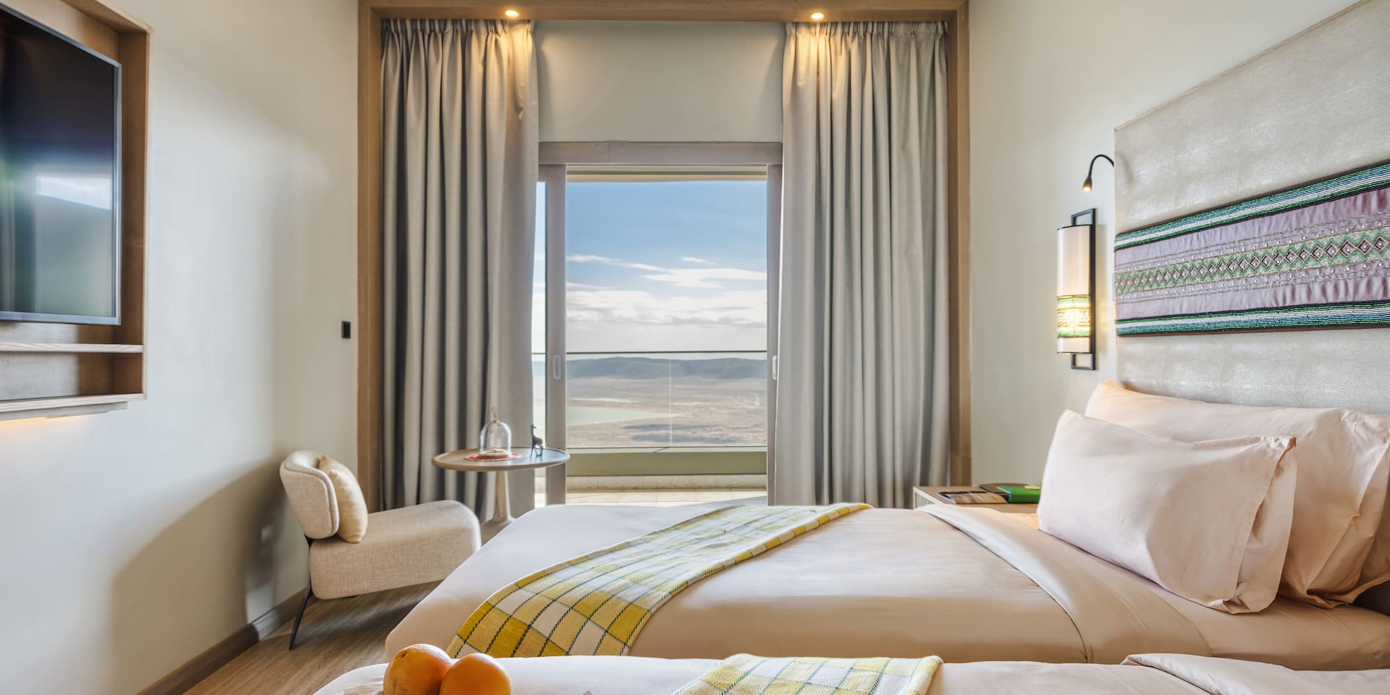 a room with two beds and a table with oranges