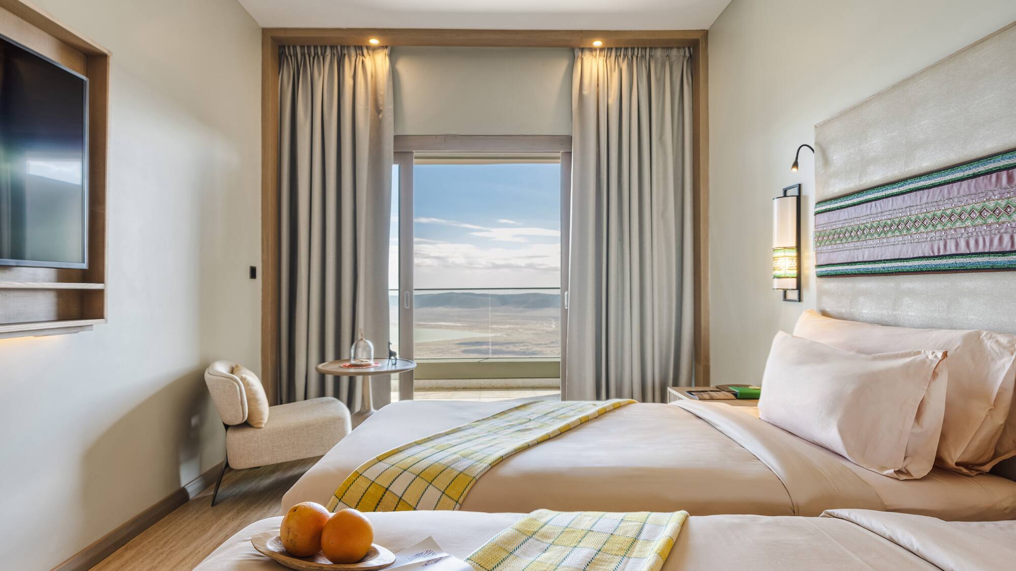 a room with two beds and a table with oranges