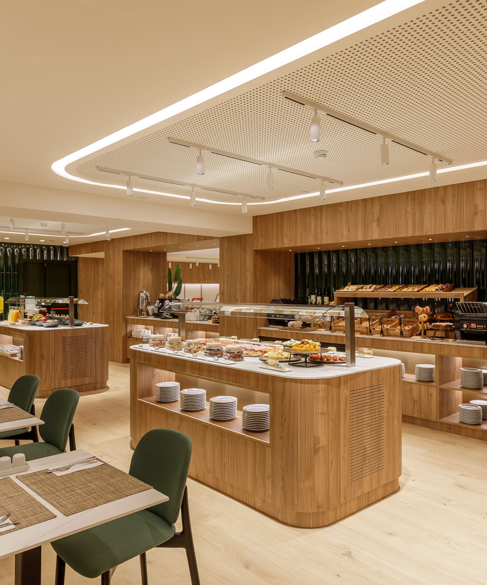 Hotel breakfast buffet with fresh food, modern wood decor, and dining tables.