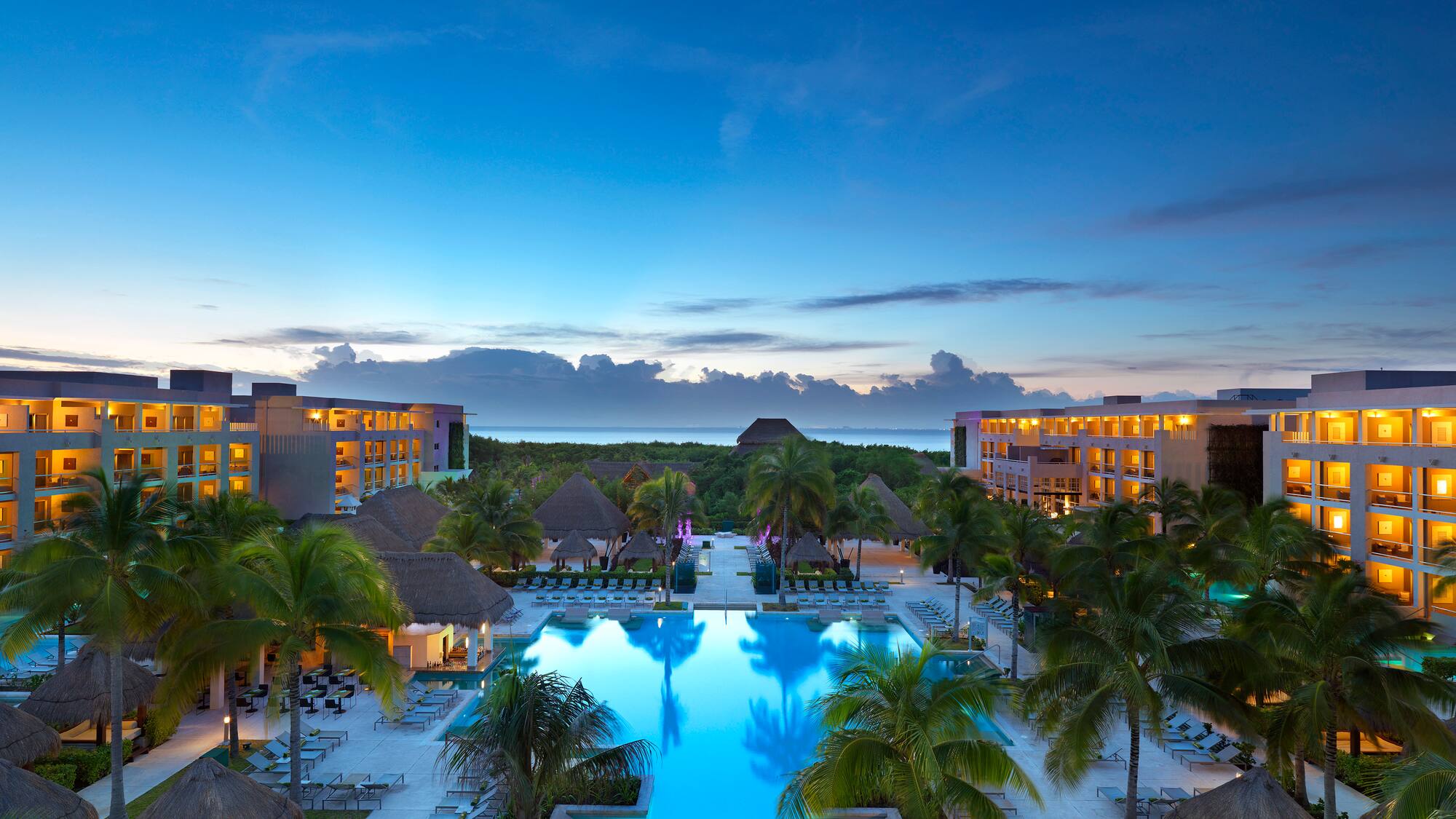 a pool with palm trees and buildings in the background