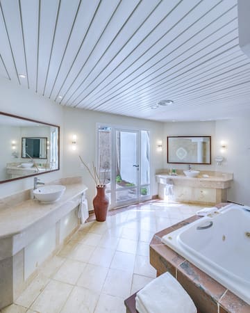 a bathroom with a tub and sinks