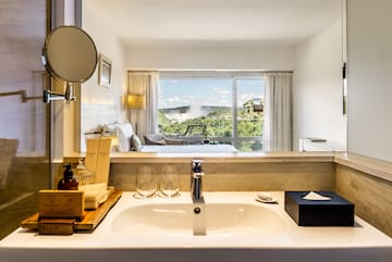 a bathroom with a window and a view of the landscape