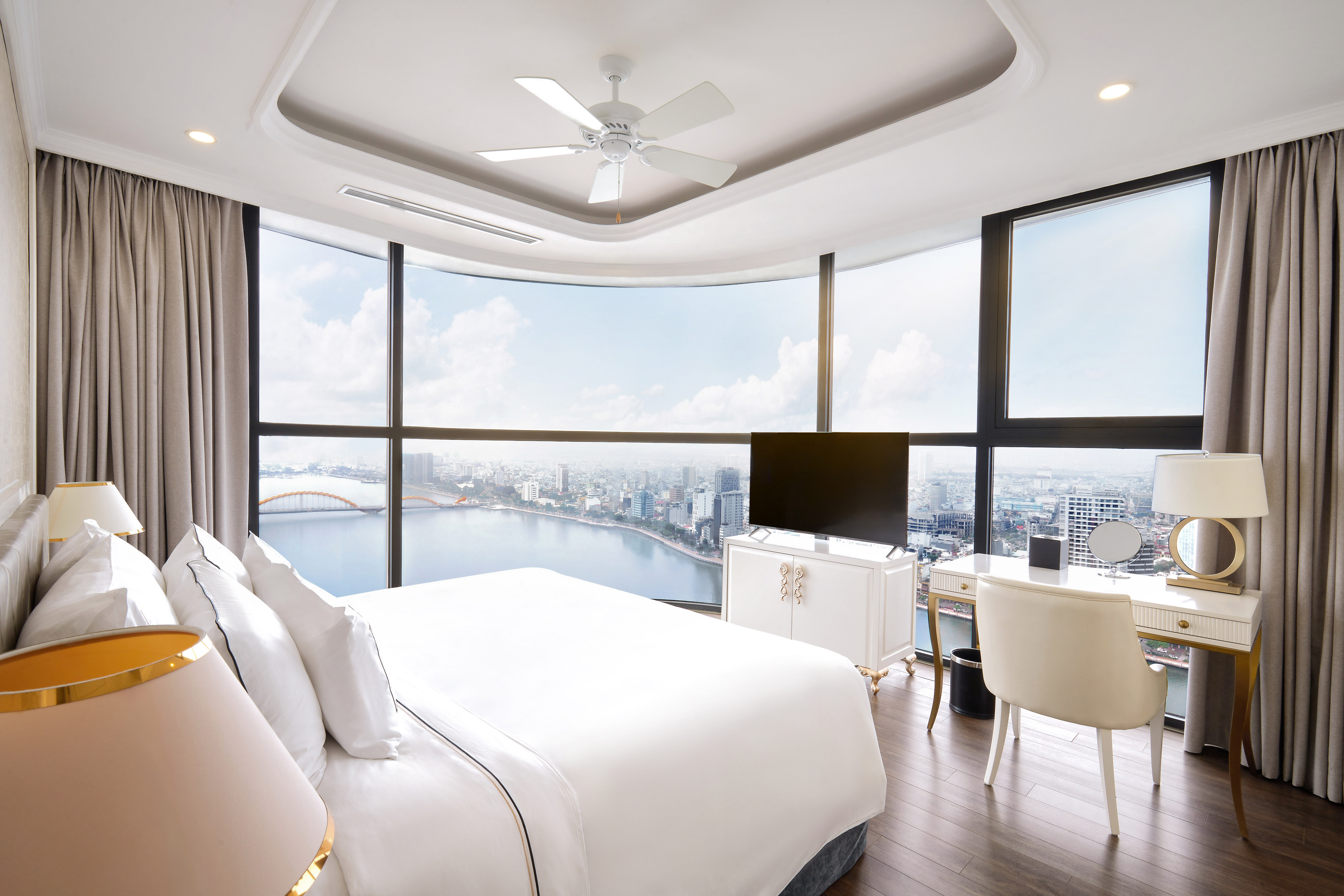 Modern hotel bedroom with panoramic city and river view.