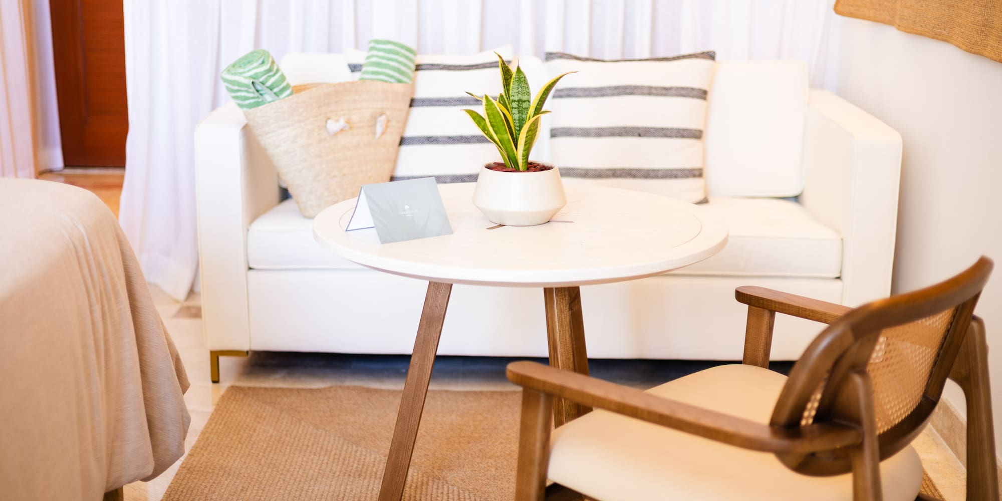 a white couch with a white table and a plant on it