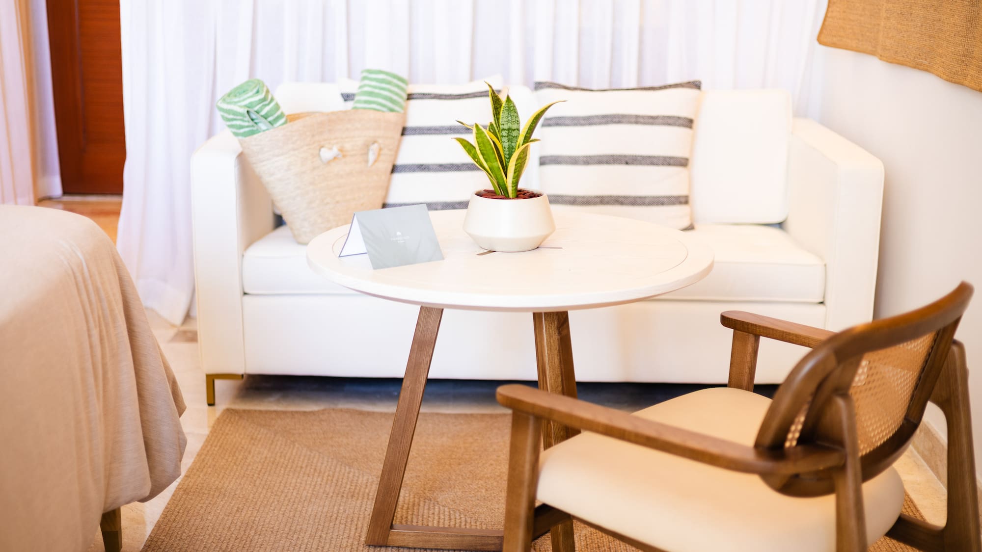 a white couch with a white table and a plant on it