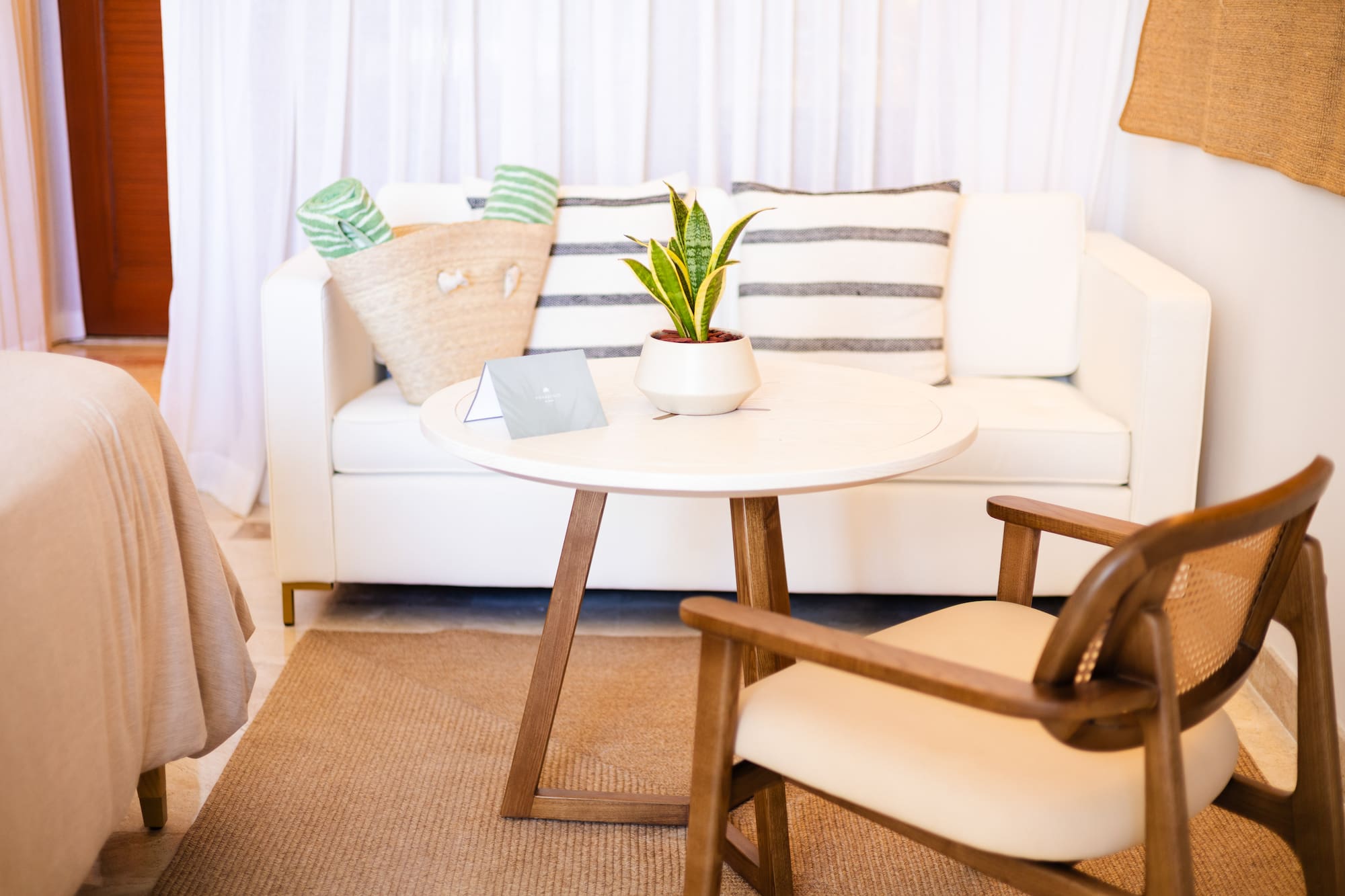a white couch with a white table and a plant on it