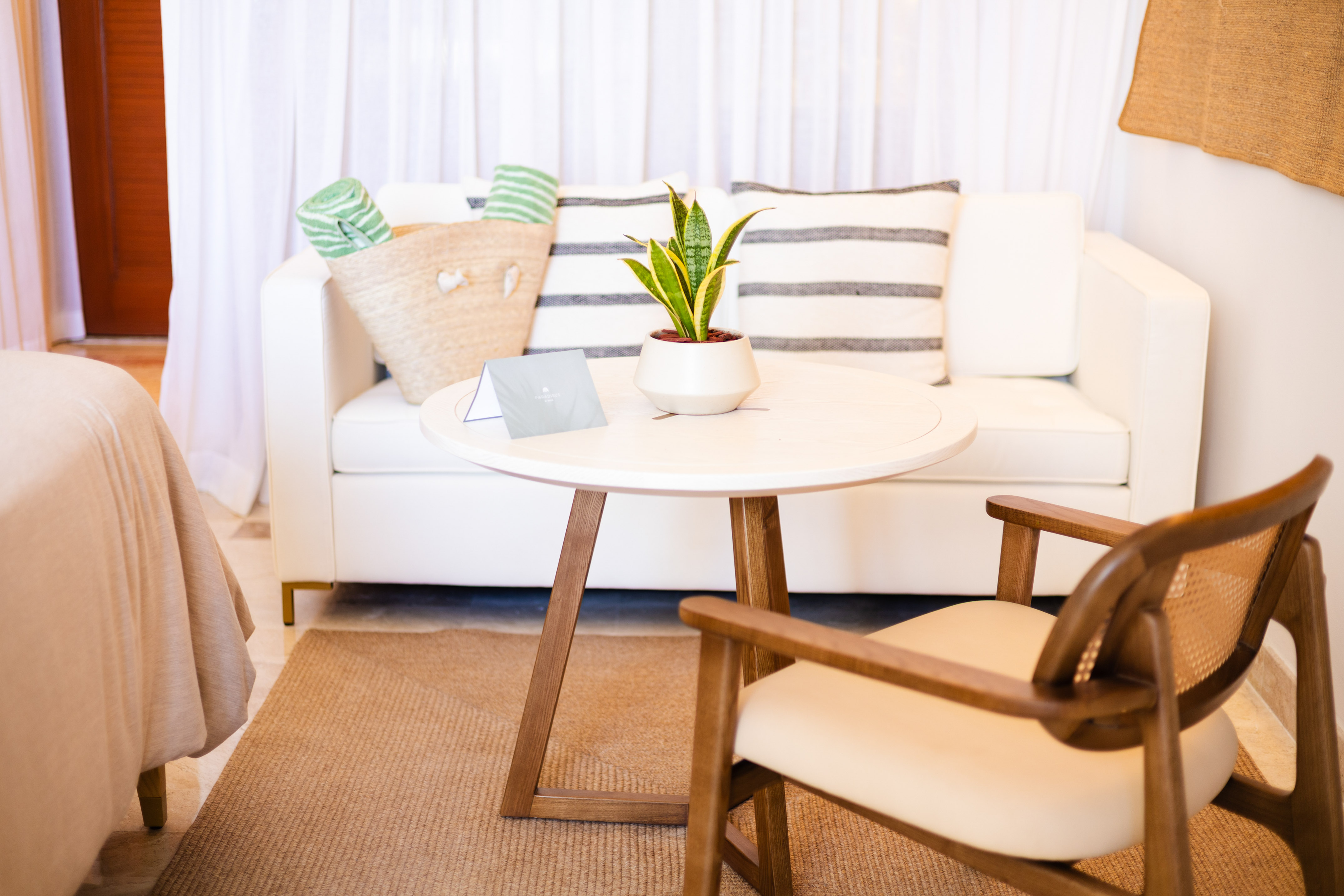 a white couch with a white table and a plant on it