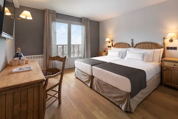 a room with two beds and a desk