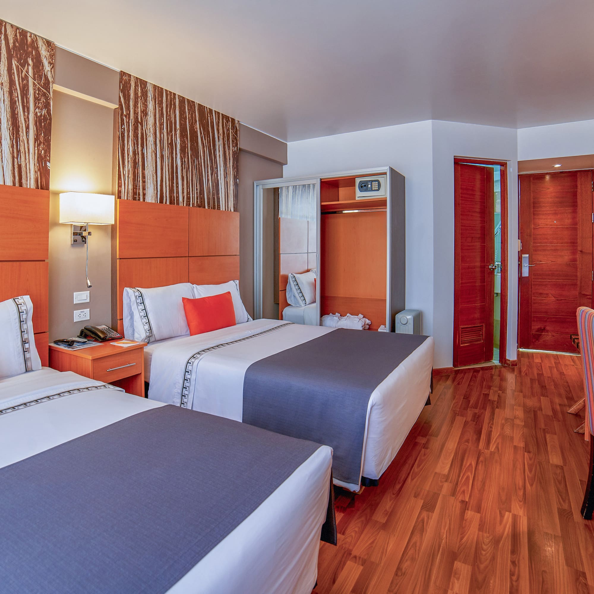 a room with two beds and a wood floor