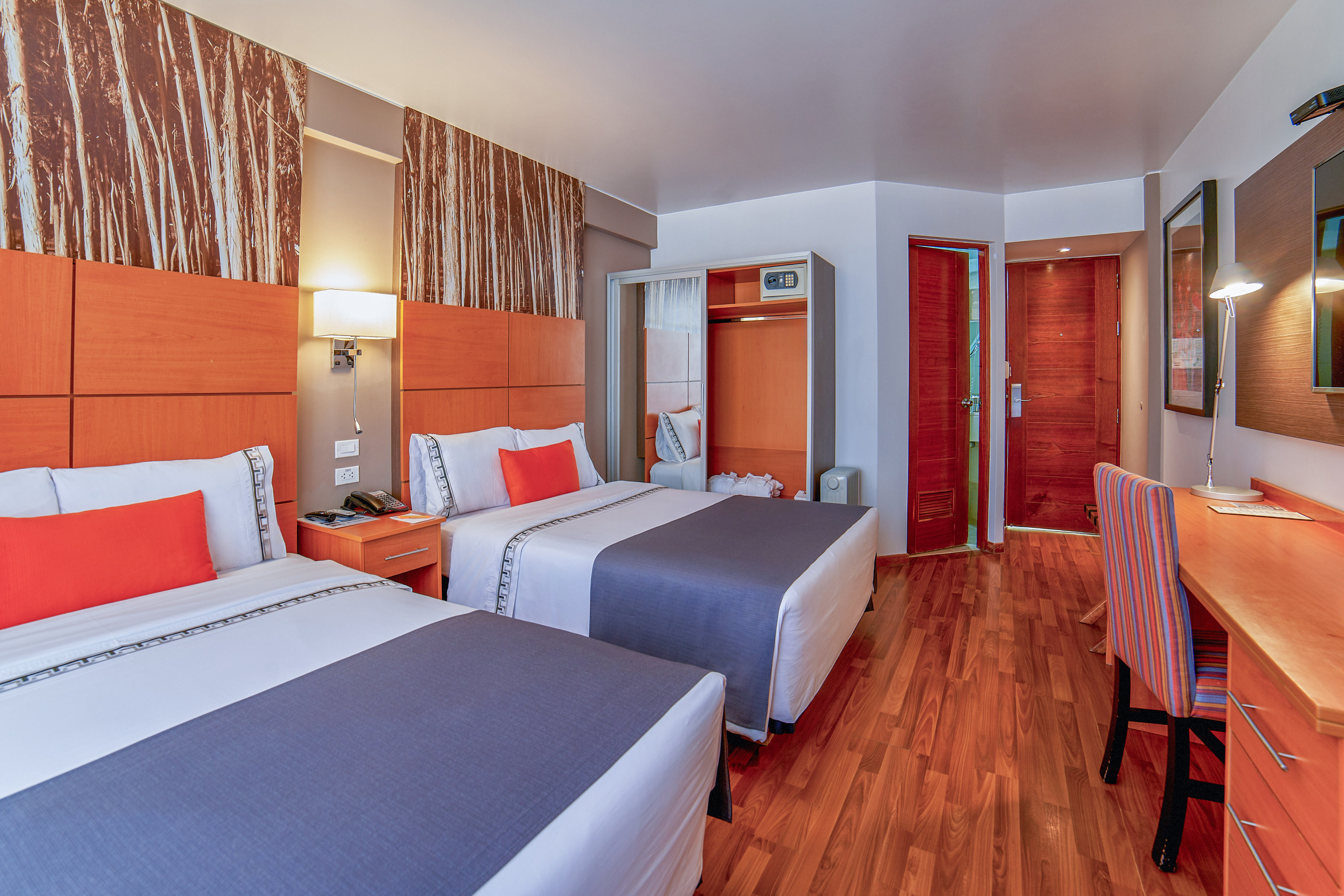 a room with two beds and a wood floor