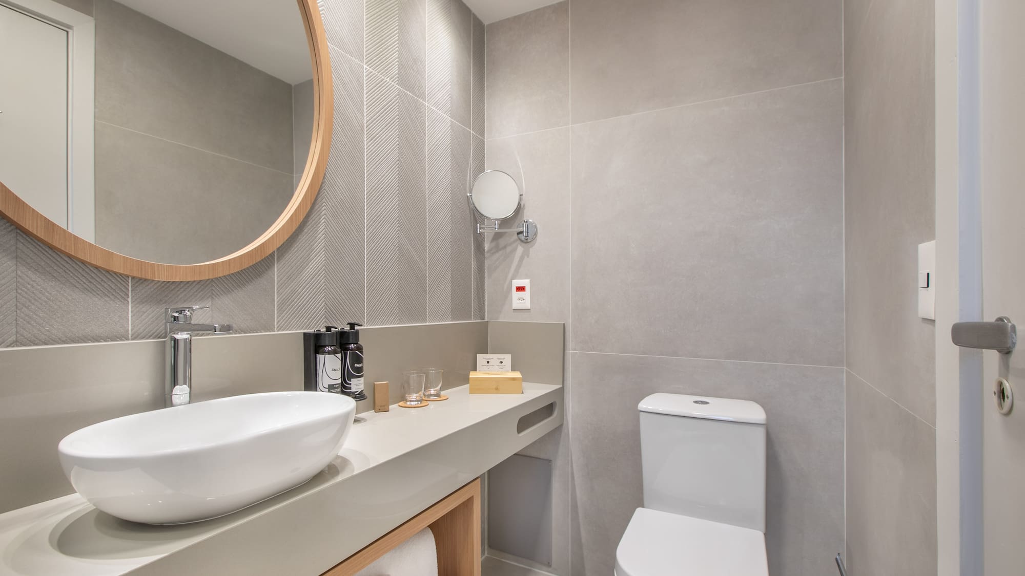 a bathroom with a round mirror and sink
