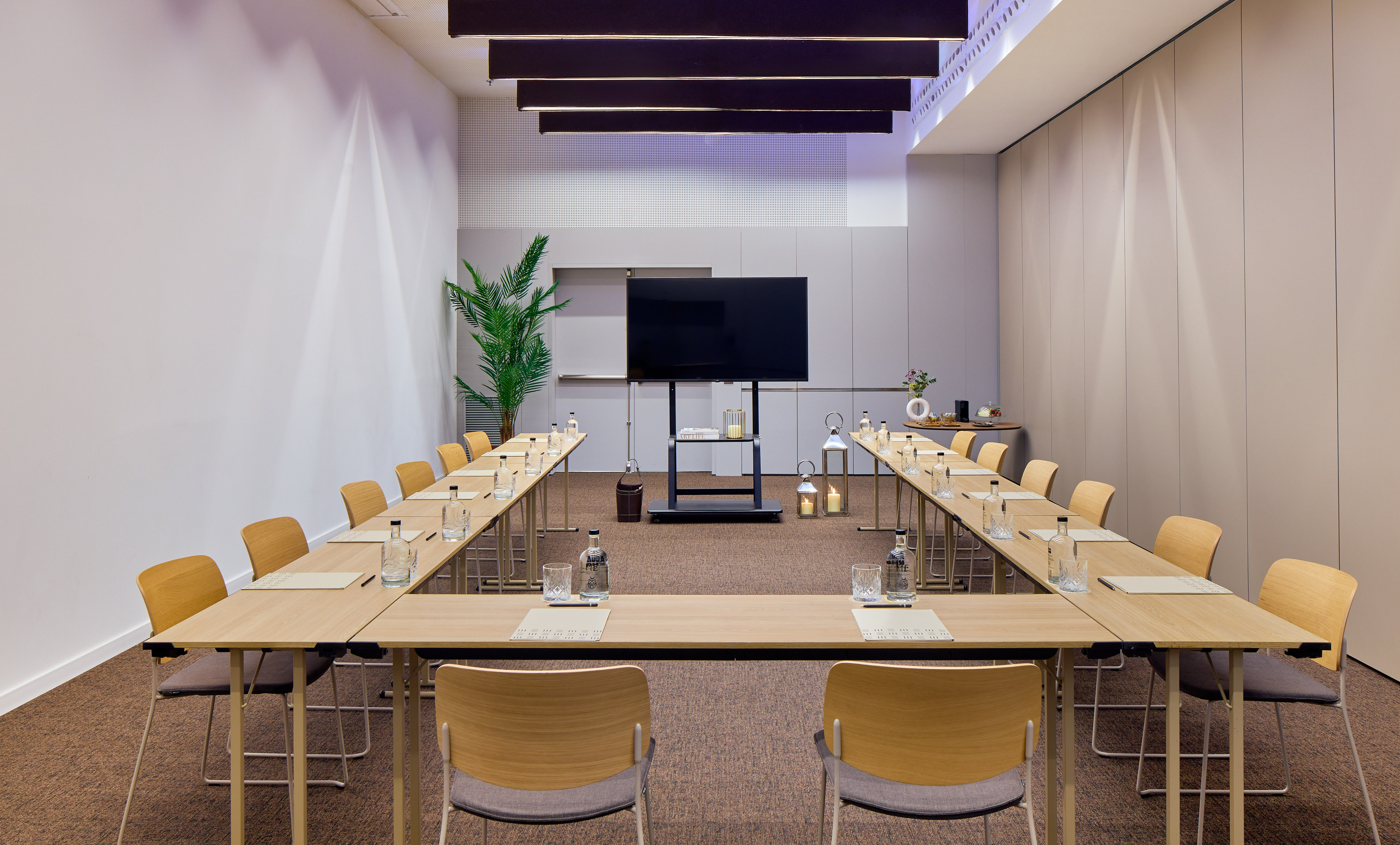 Modern U-shape corporate meeting room with large screen for presentations.
