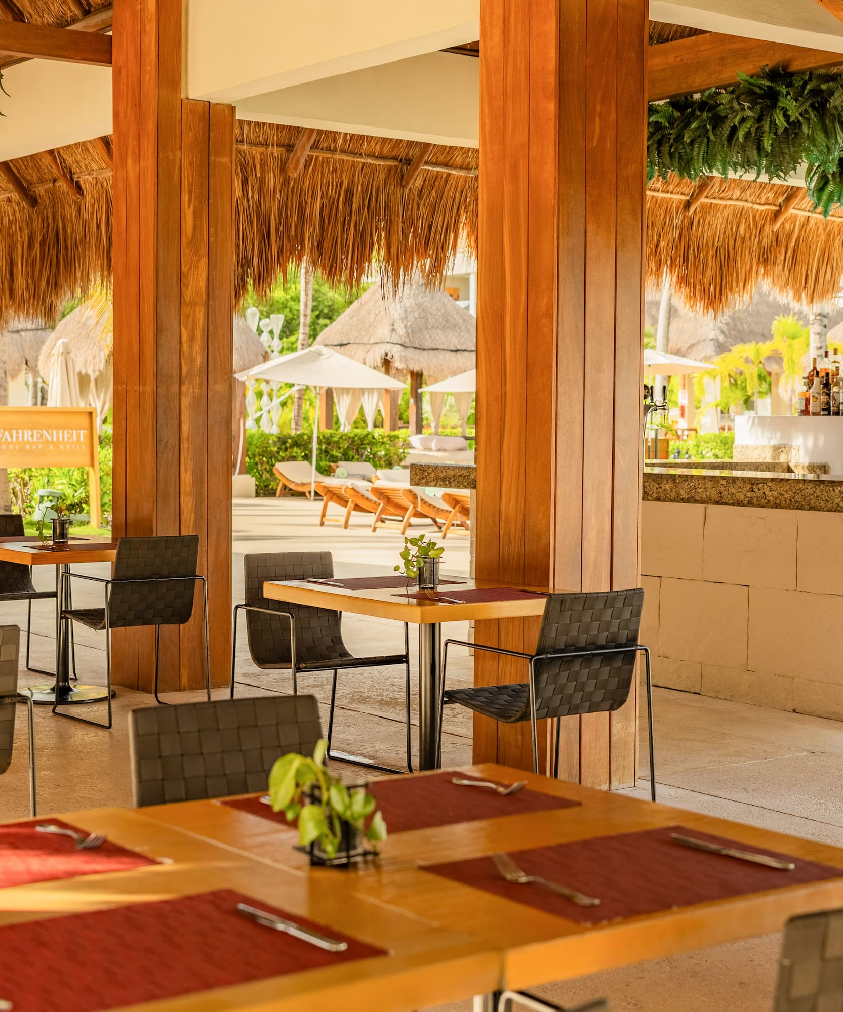 Fahrenheit Pool Bar & Grill outdoor resort restaurant with thatched roof and bar.