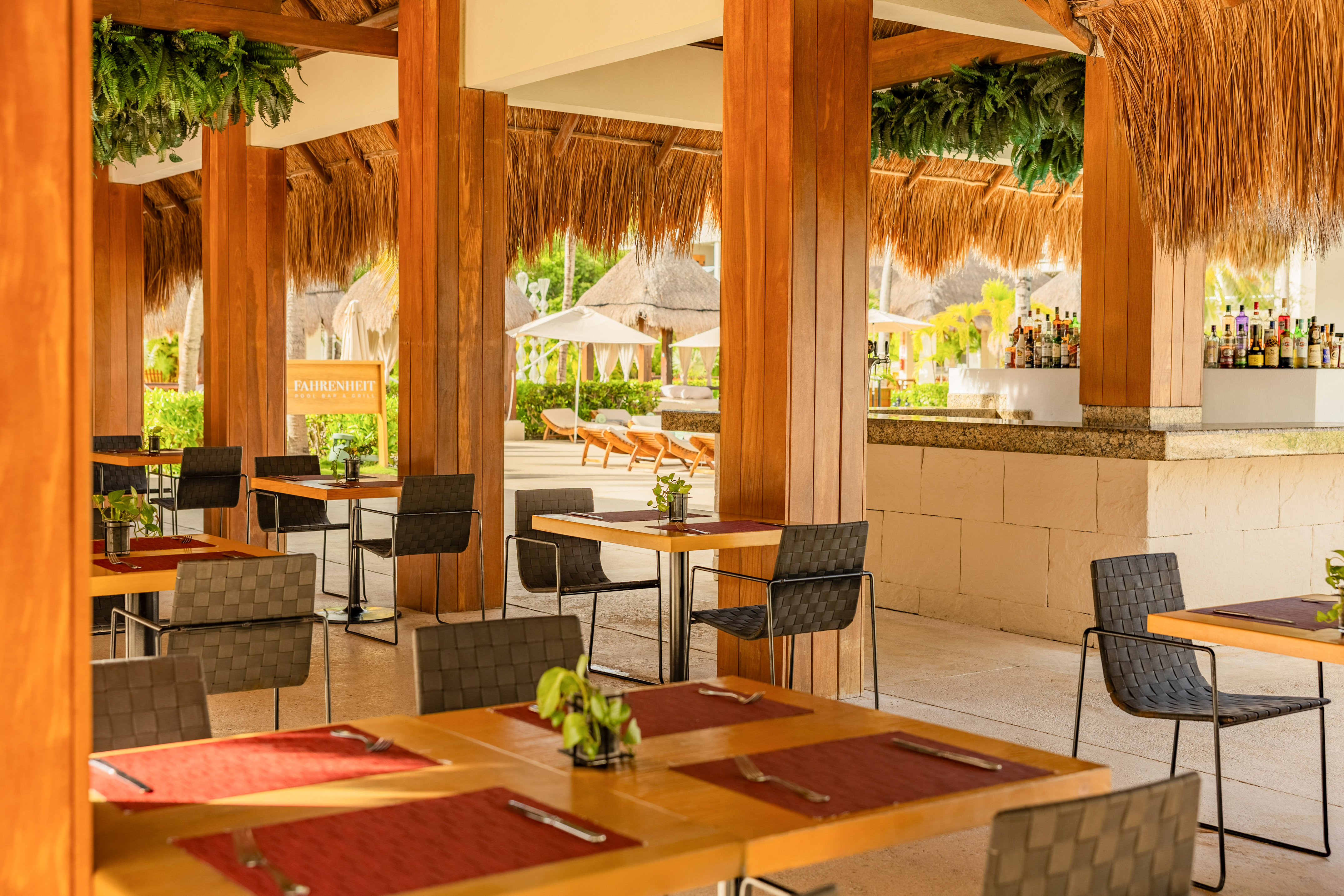 Fahrenheit Pool Bar & Grill outdoor resort restaurant with thatched roof and bar.