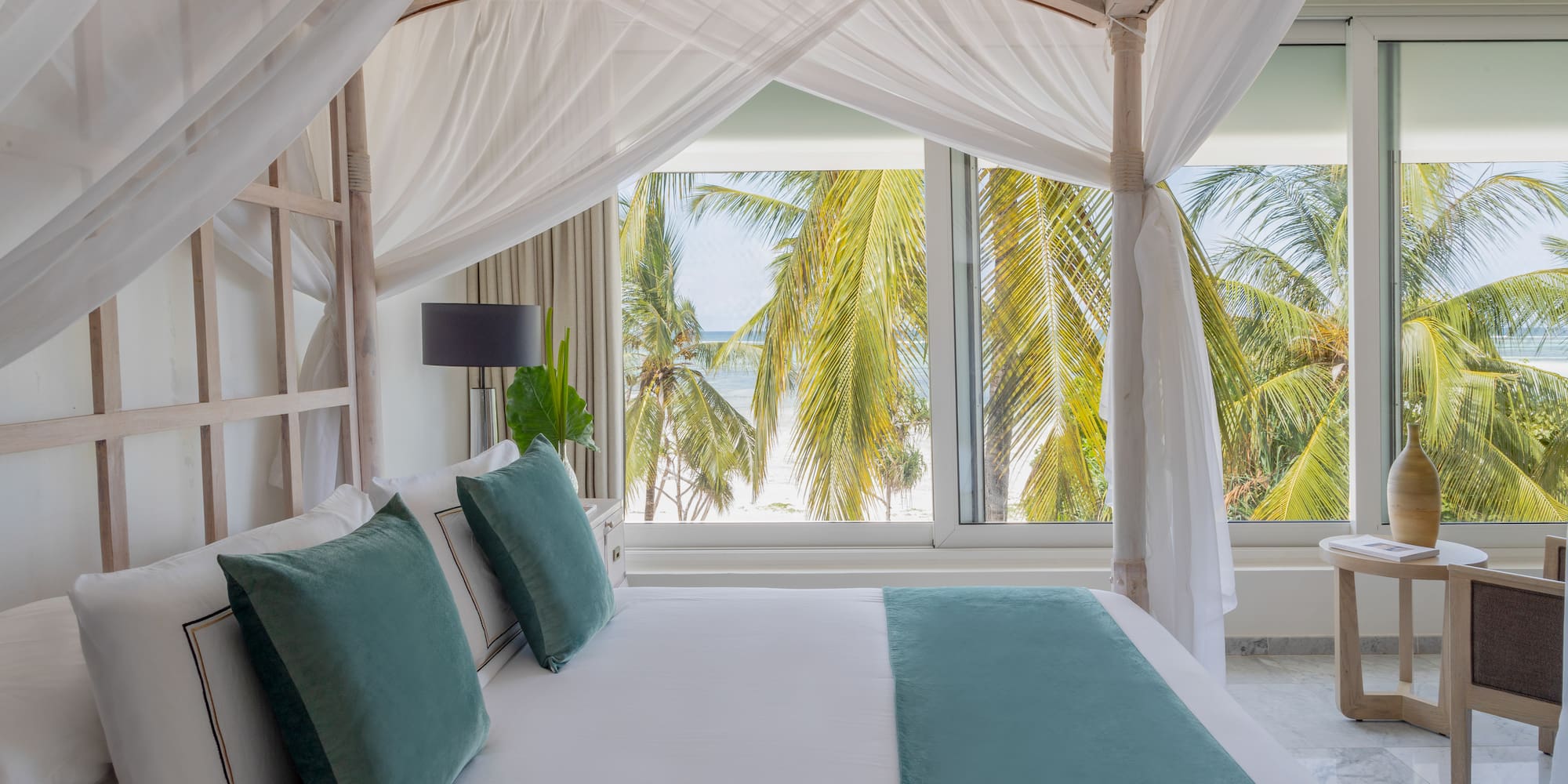 a bed with white sheets and green pillows