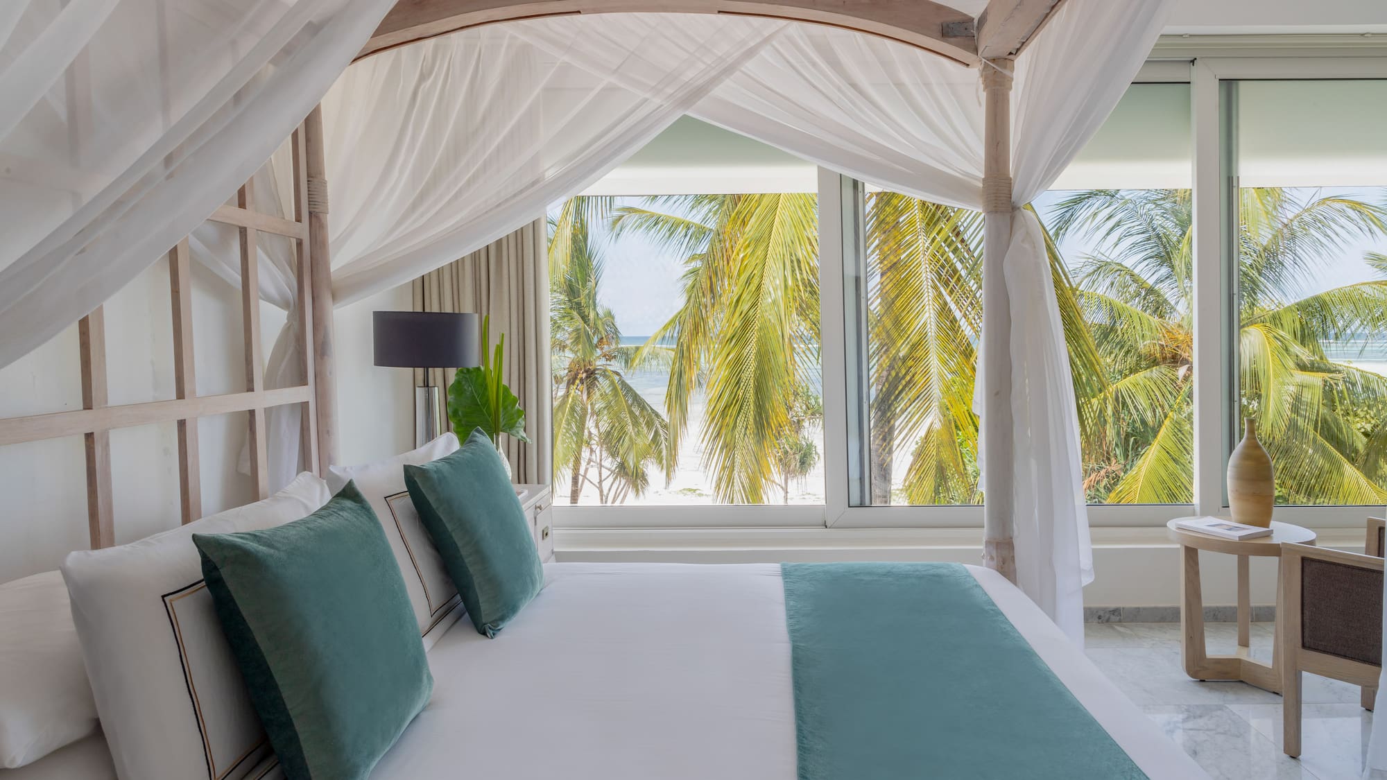a bed with white sheets and green pillows