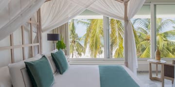 a bed with white sheets and green pillows