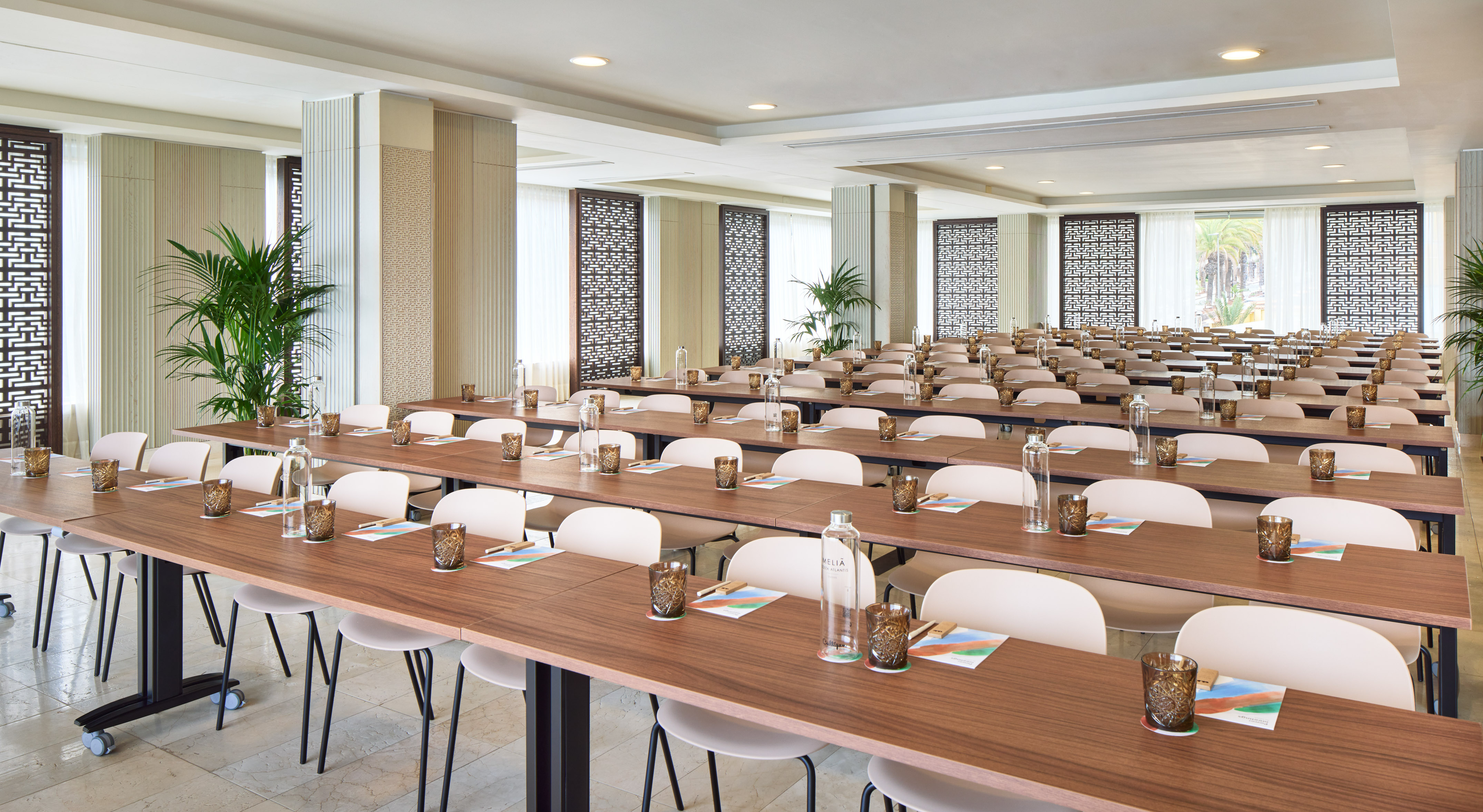 Modern conference room setup for meetings with tables, chairs, and plants.