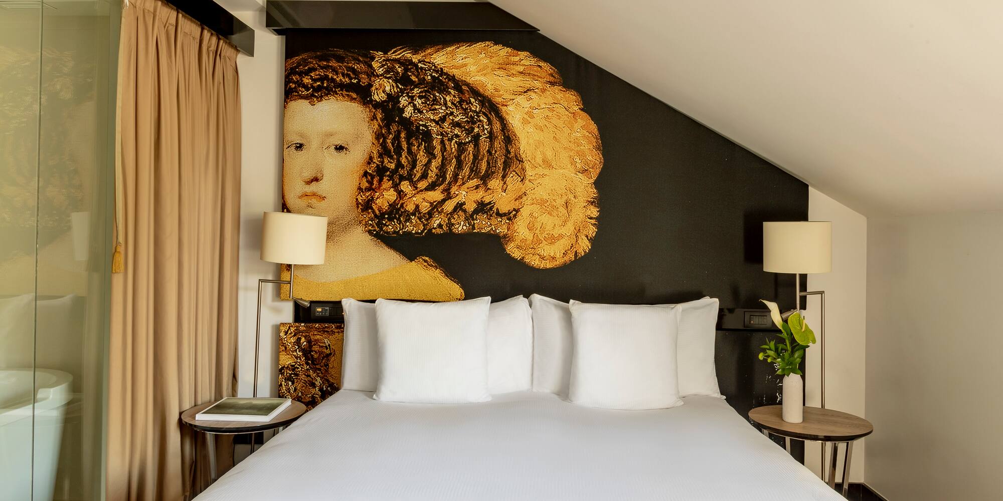 a bed with white sheets and a painting on the wall