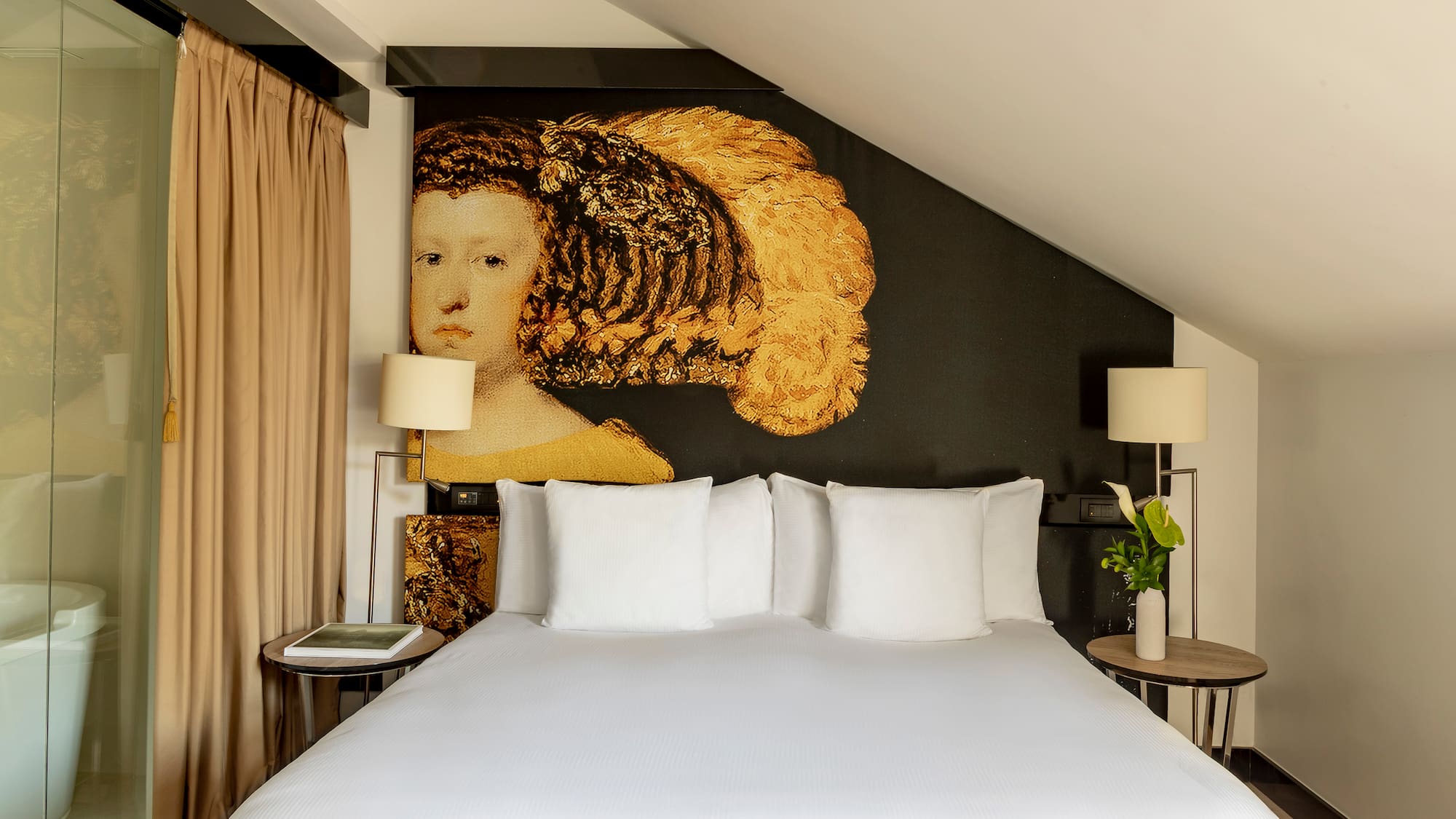 a bed with white sheets and a painting on the wall