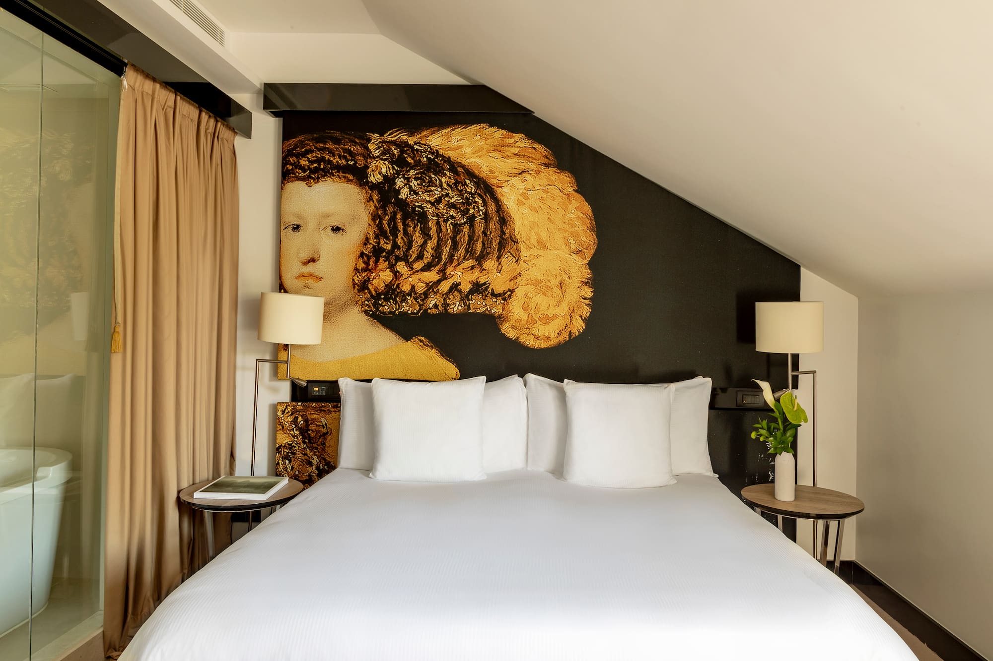 a bed with white sheets and a painting on the wall
