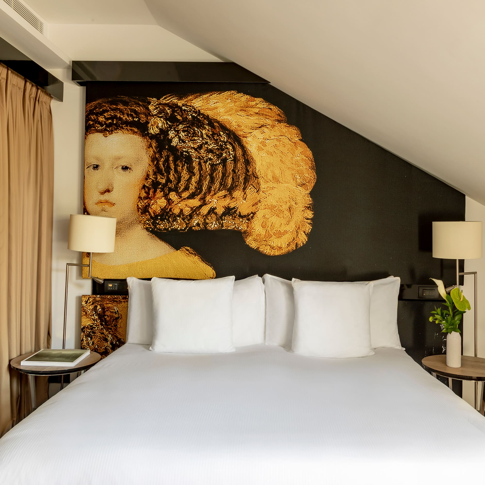 a bed with white sheets and a painting on the wall