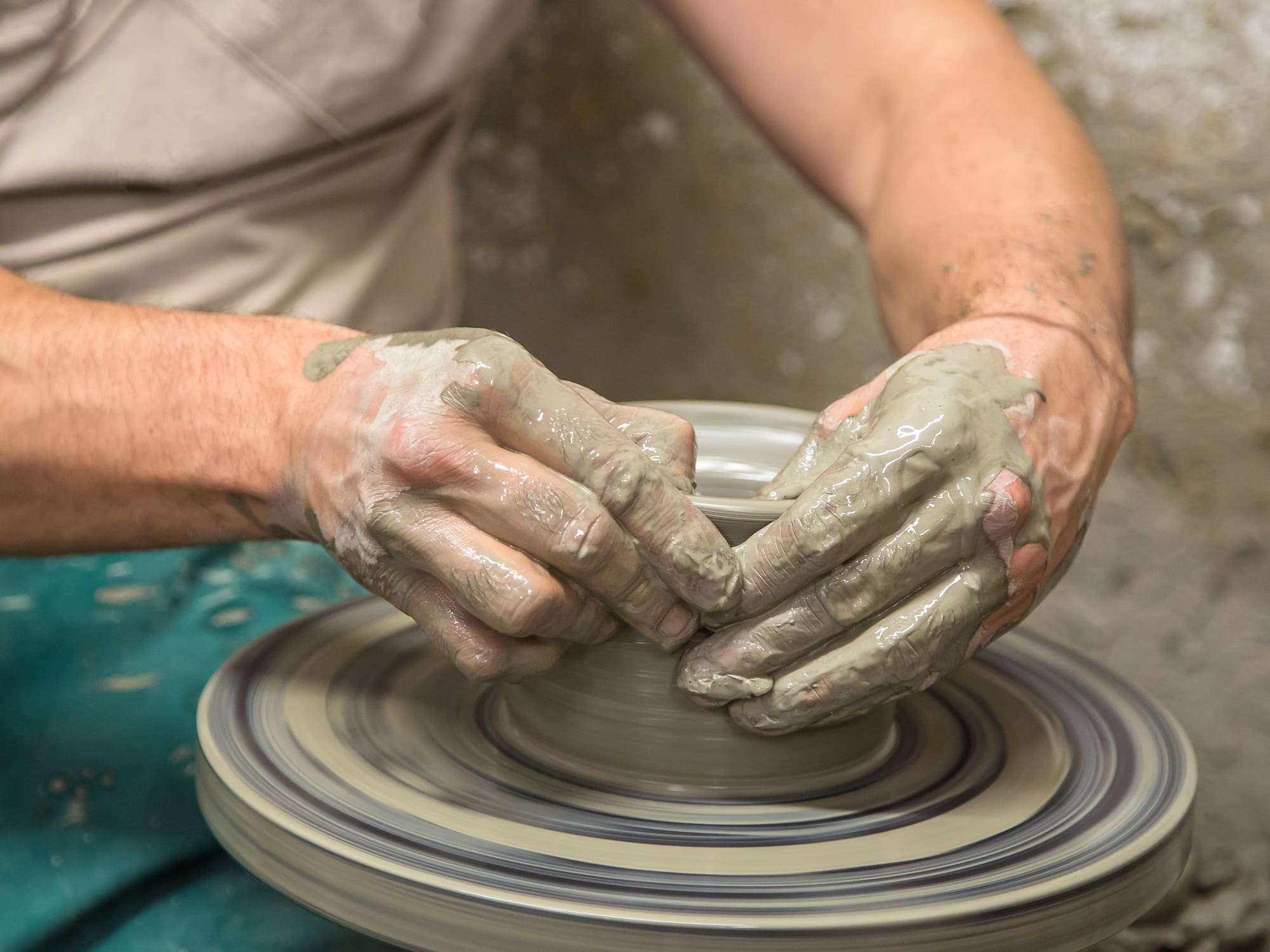 a person making a clay pot