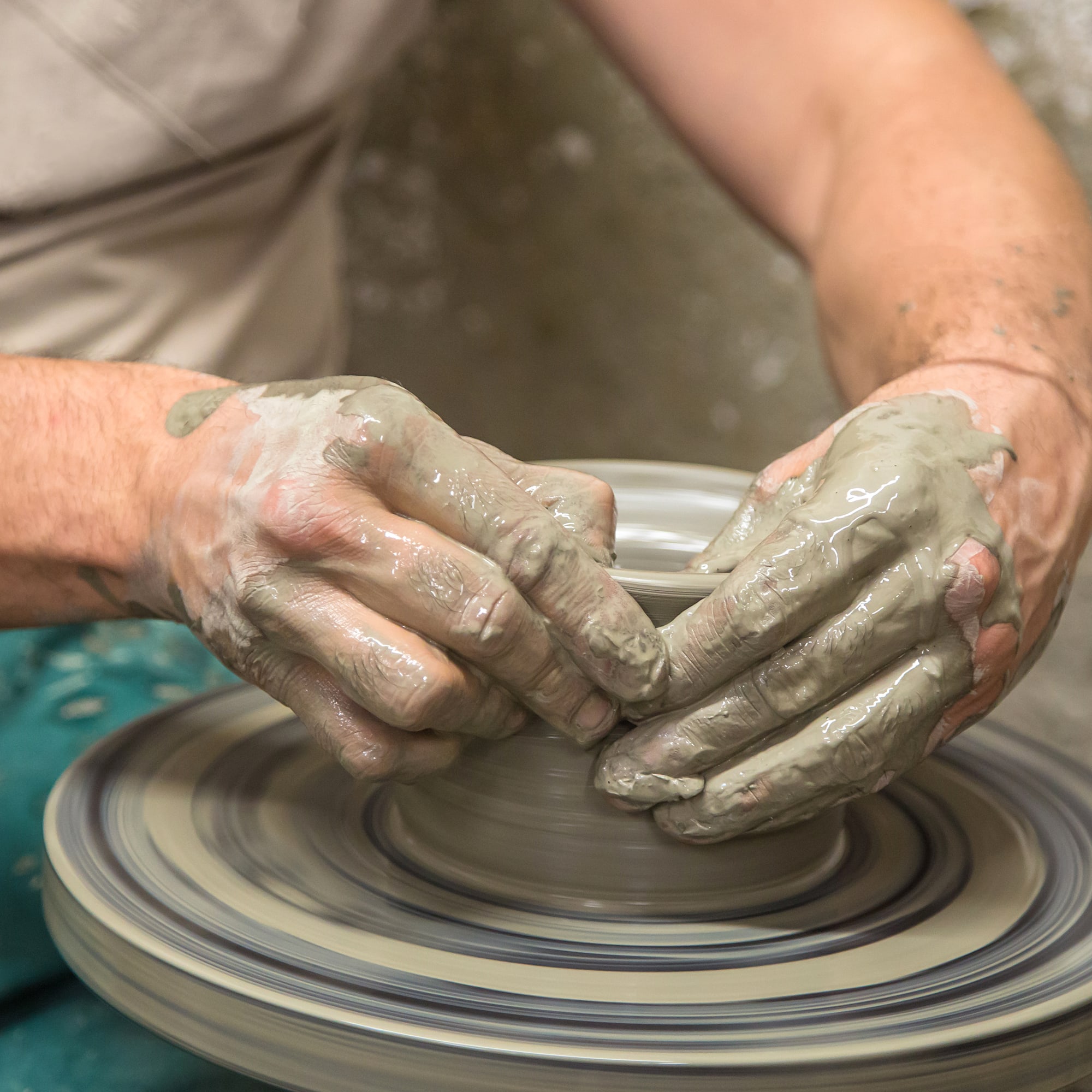 a person making a clay pot