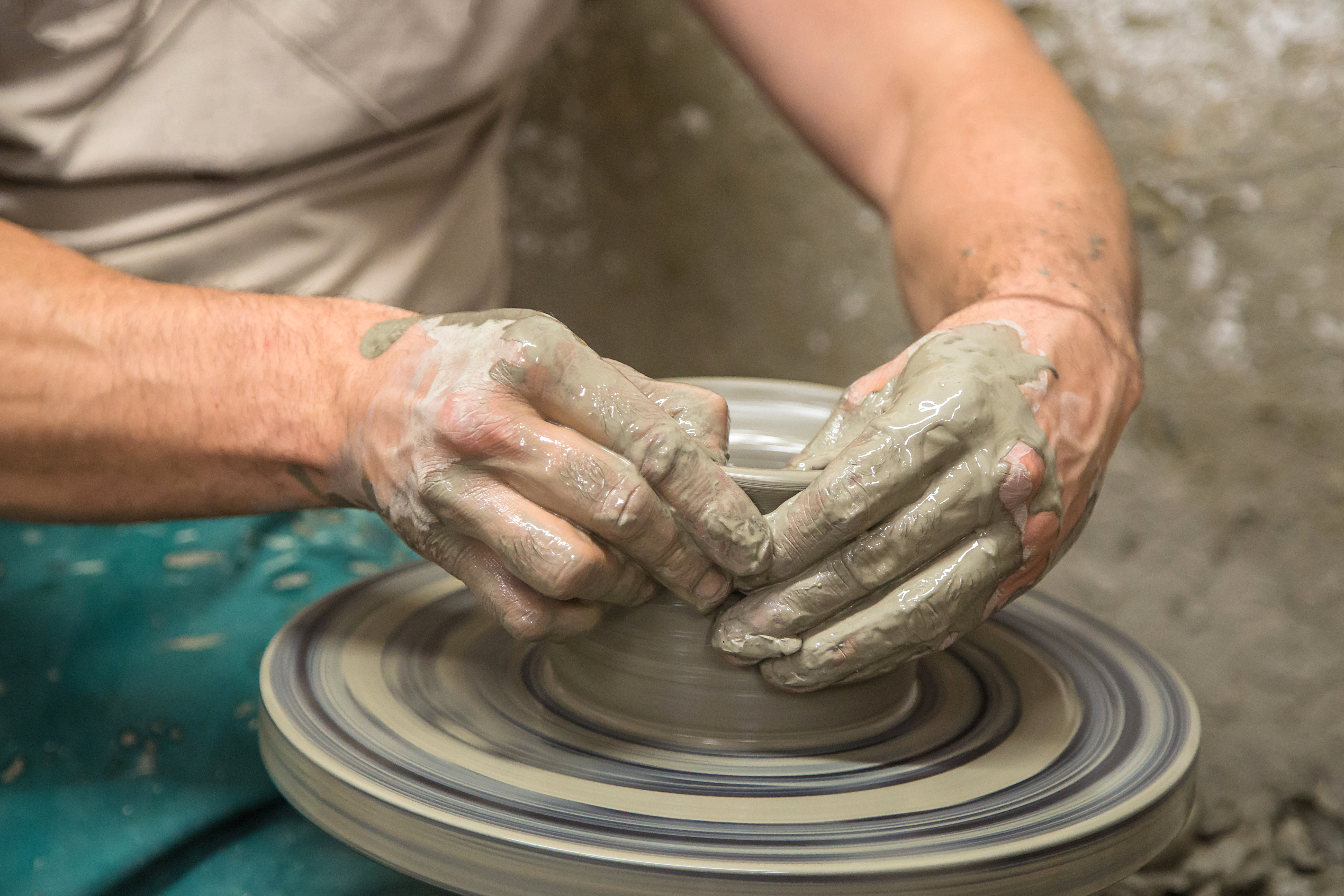 a person making a clay pot