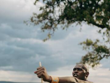 a man holding a stick in a field