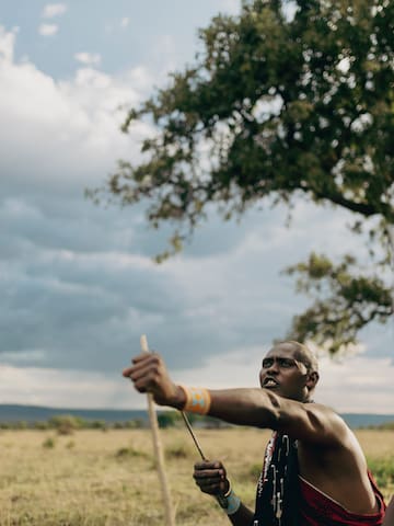 a man holding a stick in a field