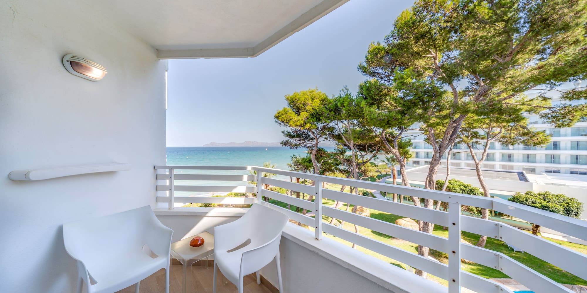 a white chairs on a balcony overlooking the ocean