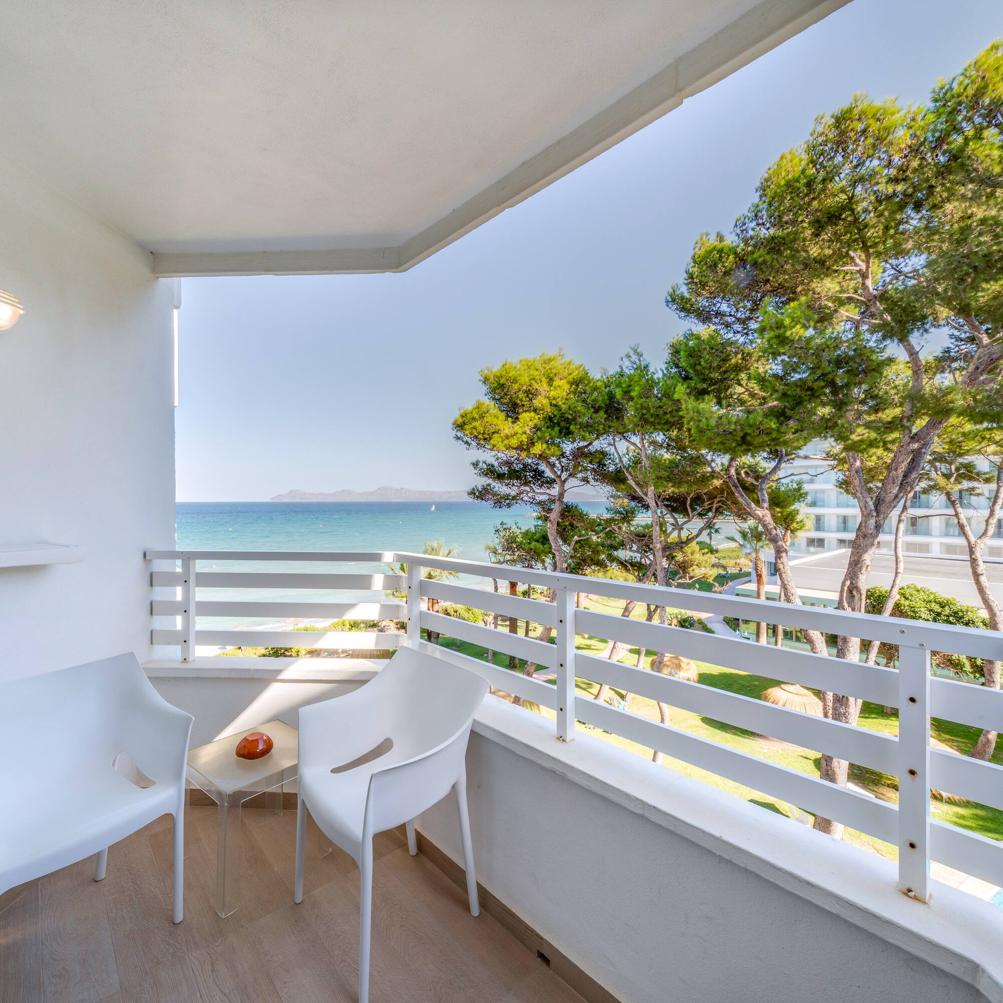 a white chairs on a balcony overlooking the ocean