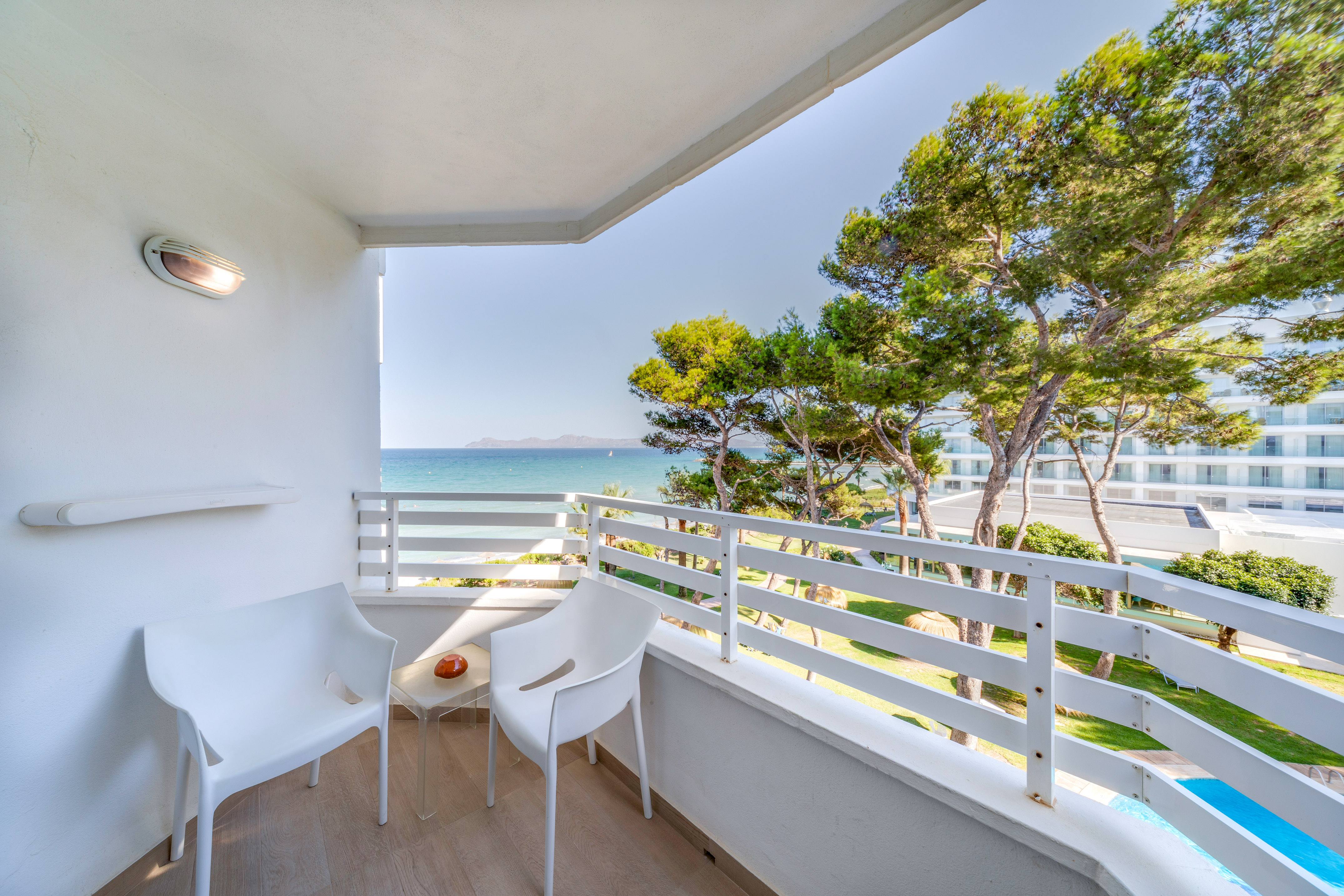 a white chairs on a balcony overlooking the ocean