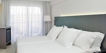 a bed with white sheets and a lamp