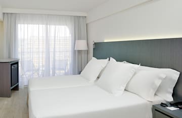 a bed with white sheets and a lamp
