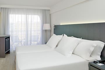 a bed with white sheets and a lamp