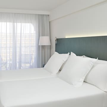 a bed with white sheets and a lamp