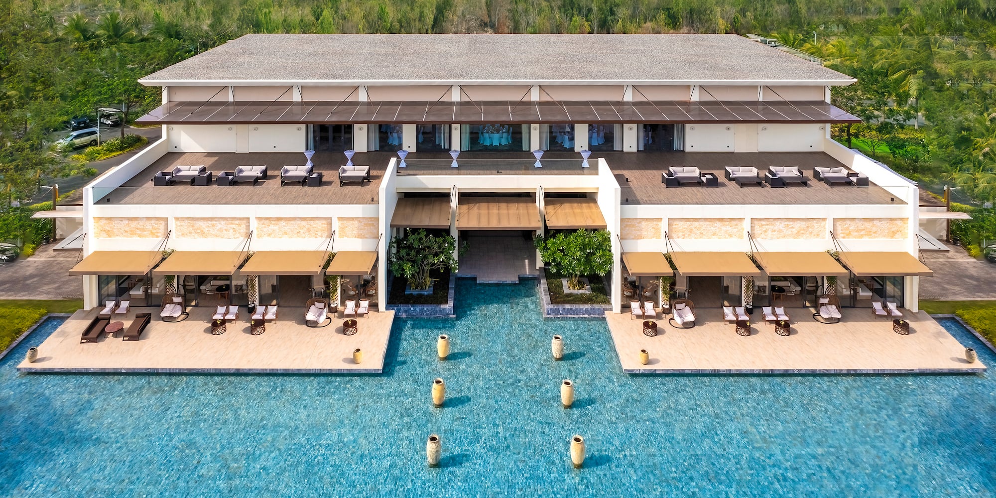 a building with a pool and trees in the background