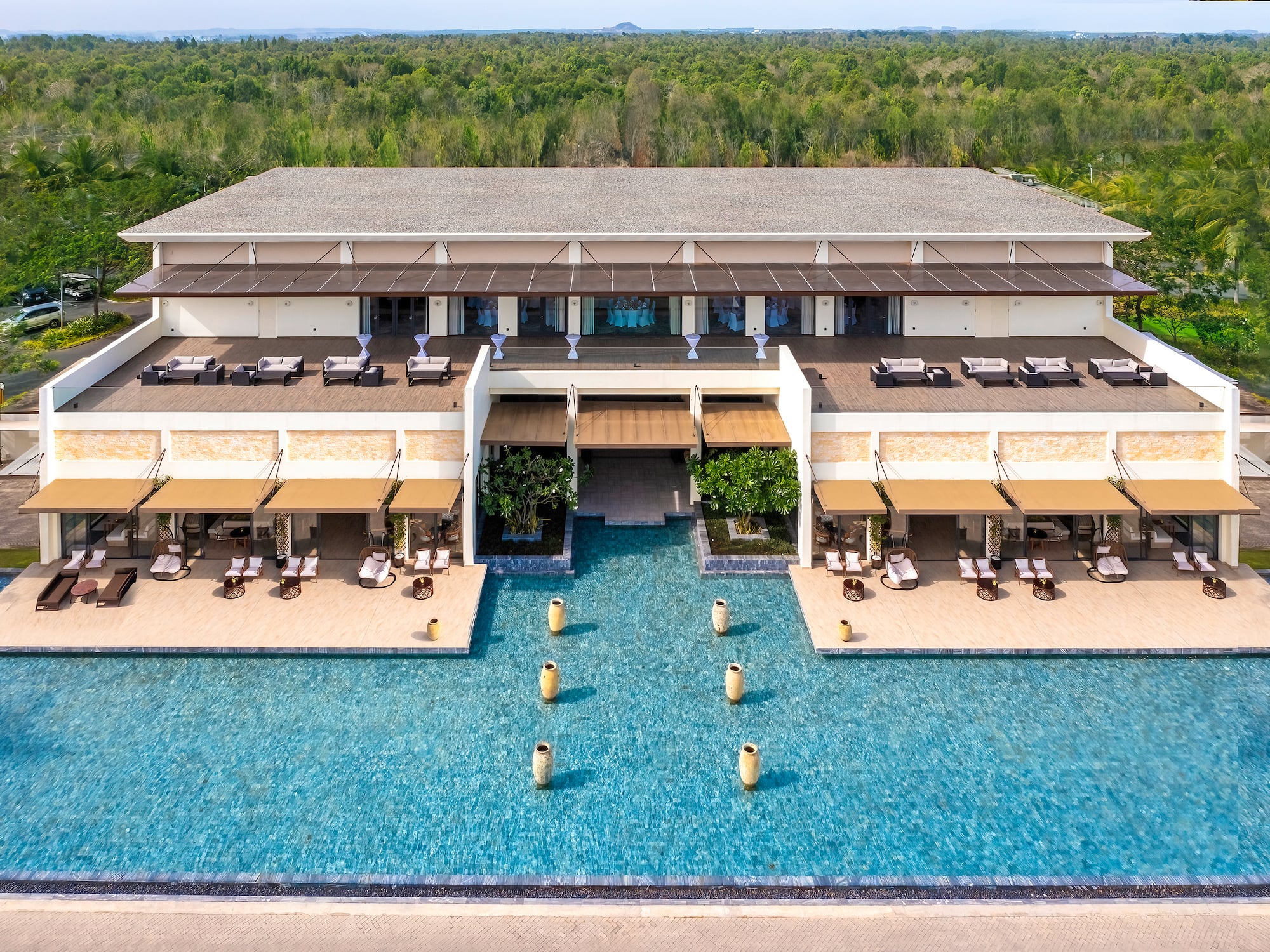 a building with a pool and trees in the background