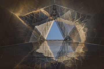 a triangular glass structure with a blue sky