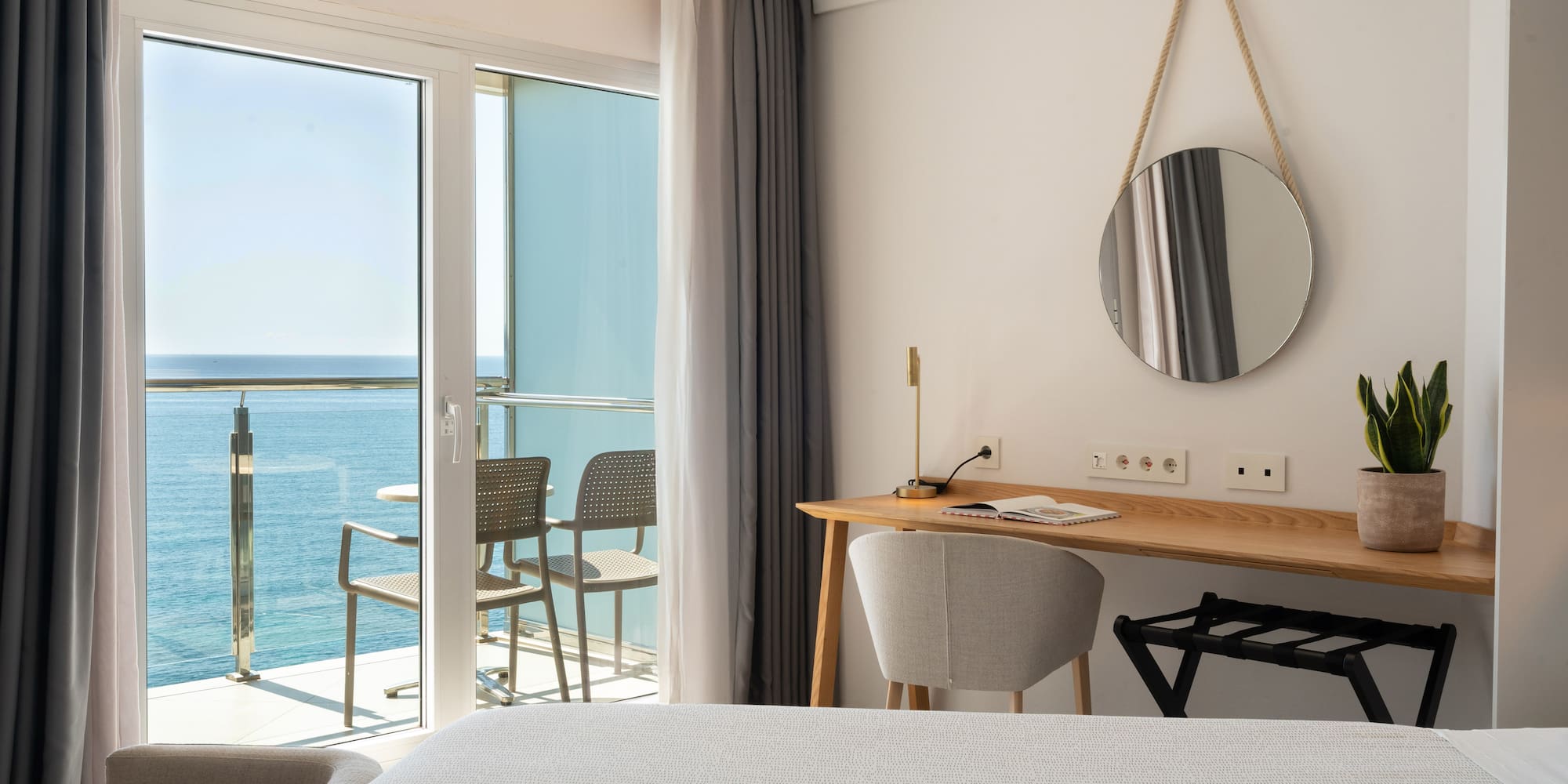 a room with a desk and chairs and a mirror on the wall