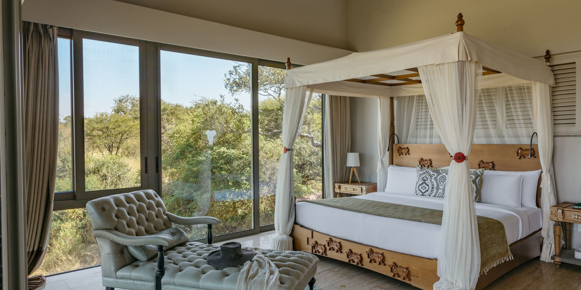 a bedroom with a canopy bed and a chaise longue