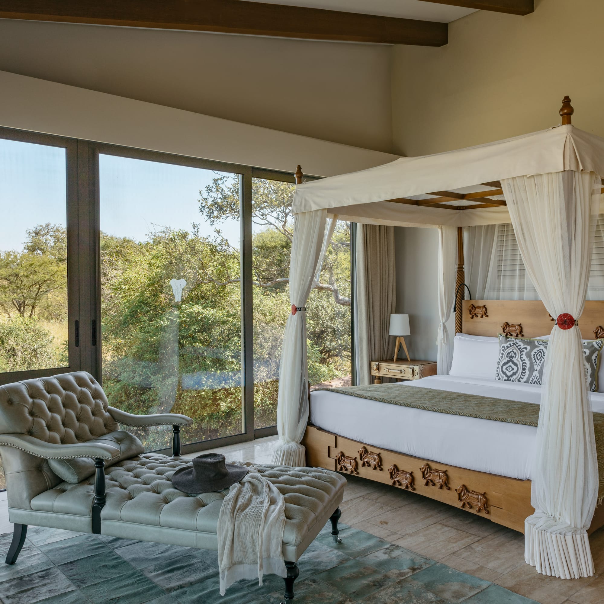 a bedroom with a canopy bed and a chaise longue